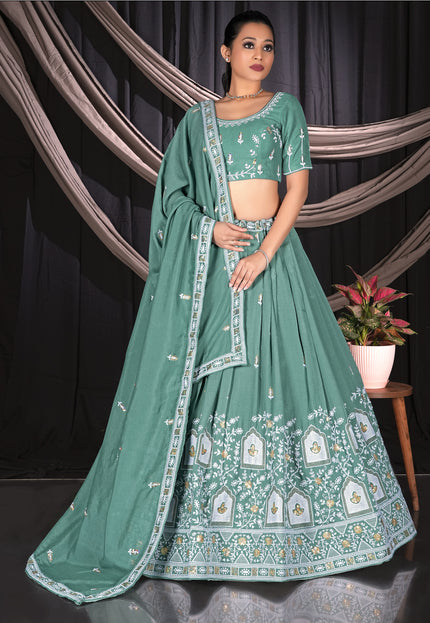 Woman wearing a green embroidered traditional outfit with a matching dupatta