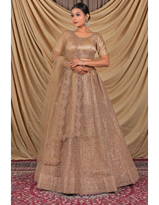 Woman wearing a beige embroidered traditional lehenga choli with dupatta