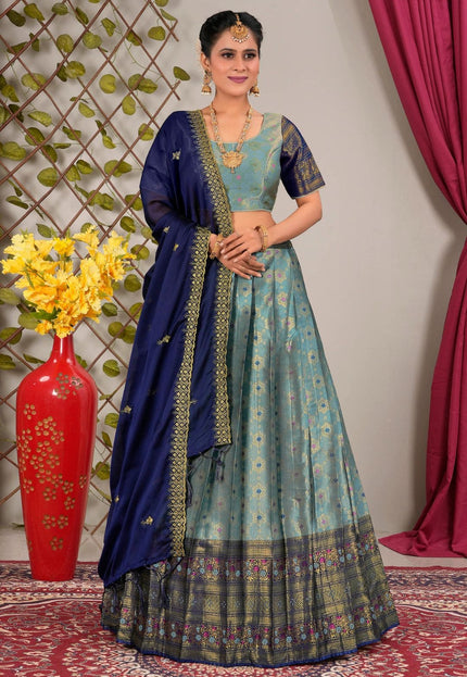 Woman wearing a traditional blue and green lehenga choli with dupatta