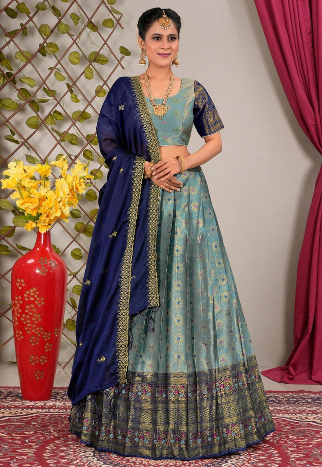 Woman wearing a traditional blue and green lehenga choli with dupatta