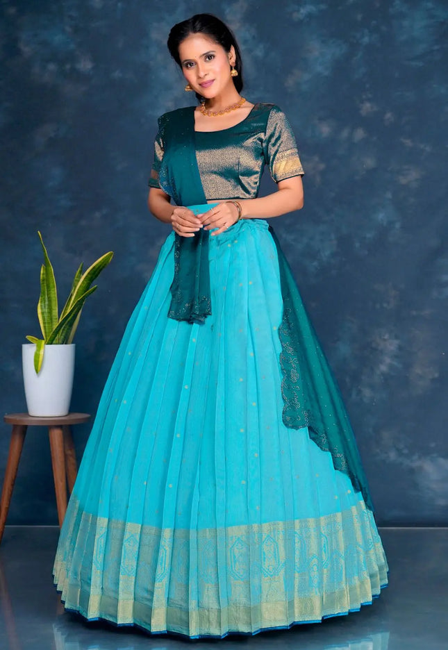 Woman wearing a sky blue and green traditional lehenga choli with dupatta