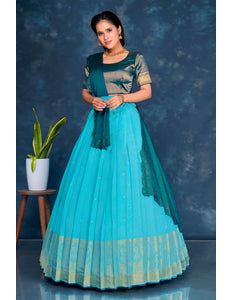 Woman wearing a sky blue and green traditional lehenga choli with dupatta