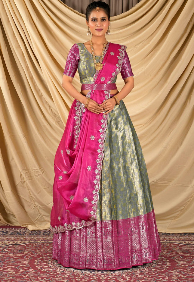 Woman wearing a traditional pink and green lehenga choli with dupatta