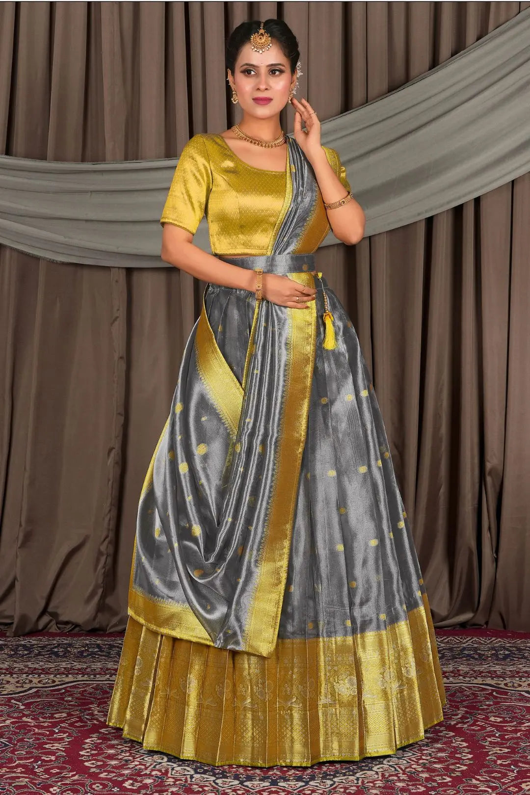 Woman wearing a traditional lehenga with a gold and gray pattern