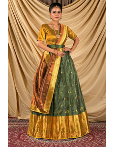 Woman wearing a traditional green and gold lehenga choli with dupatta