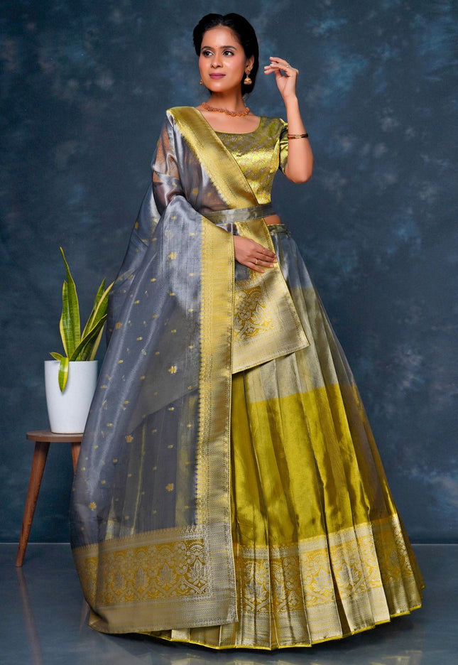 Woman wearing a traditional green and gray lehenga choli with dupatta
