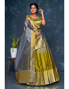 Woman wearing a traditional green and gray lehenga choli with dupatta