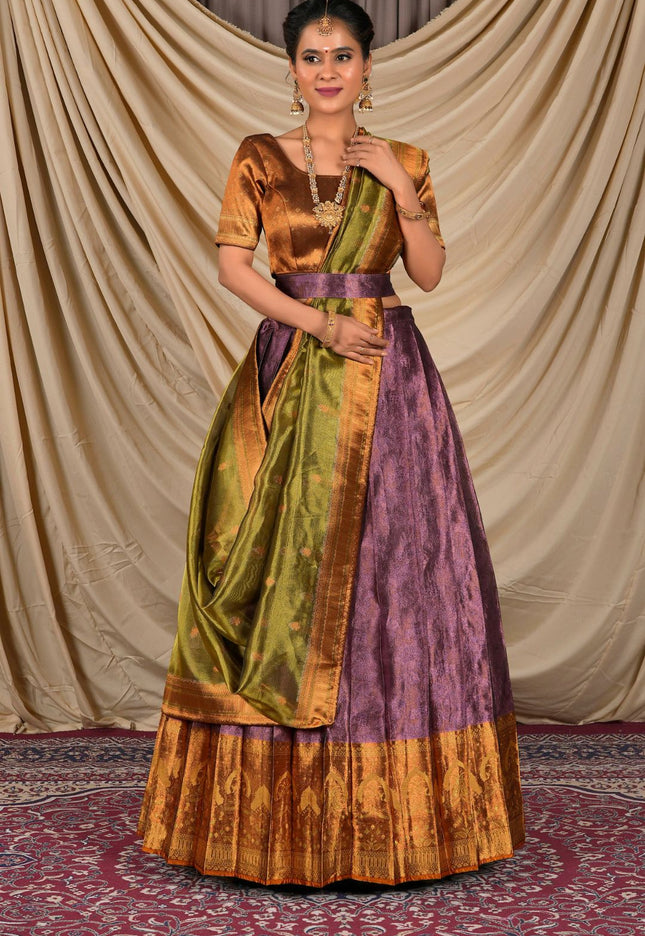 Woman wearing a traditional outfit with a gold, green, and purple lehenga choli with dupatta