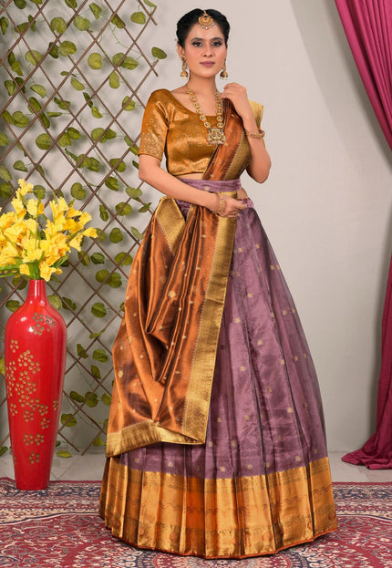 Woman in a traditional gold and purple lehenga choli with dupatta