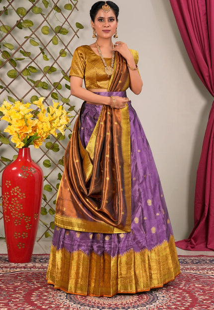 Woman in a traditional purple and gold lehenga choli with dupatta