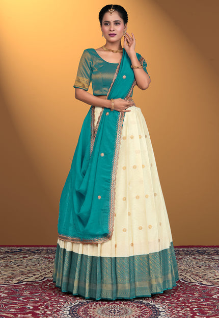 Woman wearing a teal and cream lehenga choli