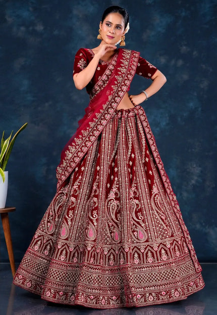 Woman wearing a traditional maroon embroidered lehenga choli with dupatta
