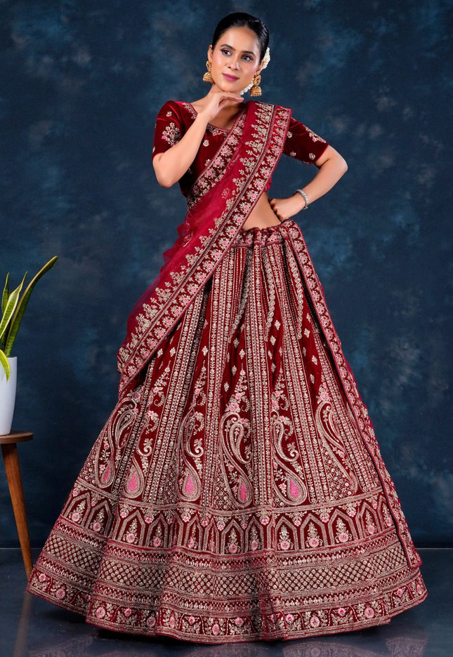 Woman wearing a traditional maroon embroidered lehenga choli with dupatta
