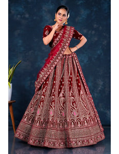 Woman wearing a traditional maroon embroidered lehenga choli with dupatta