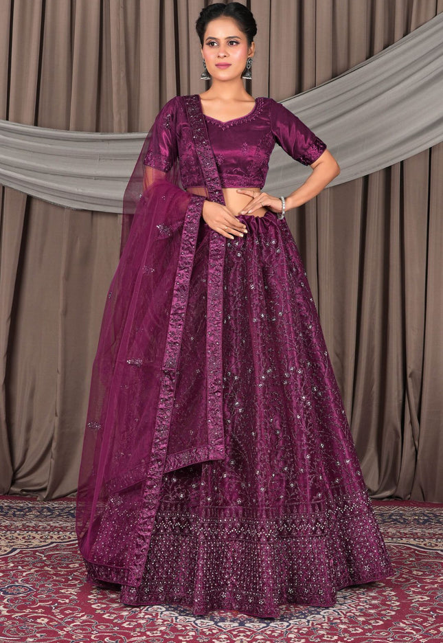 Woman wearing a traditional purple embroidered outfit with a matching dupatta