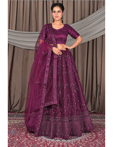 Woman wearing a traditional purple embroidered outfit with a matching dupatta