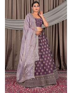 Woman wearing a traditional purple and gray lehenga with a matching dupatta