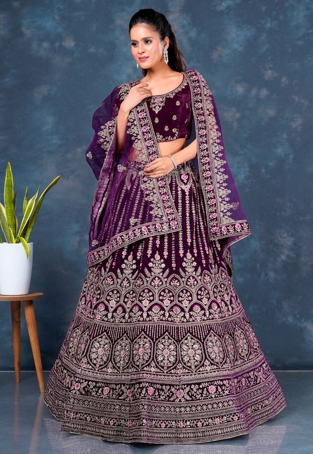 Woman wearing a traditional purple embroidered lehenga choli with dupatta