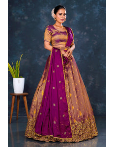 Woman wearing a traditional purple and gold lehenga choli with dupatta
