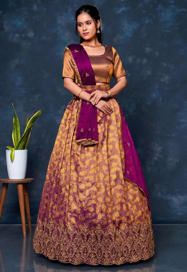 Woman wearing a traditional outfit with a purple and gold lehenga choli with dupatta