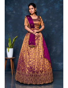 Woman wearing a traditional outfit with a purple and gold lehenga choli with dupatta