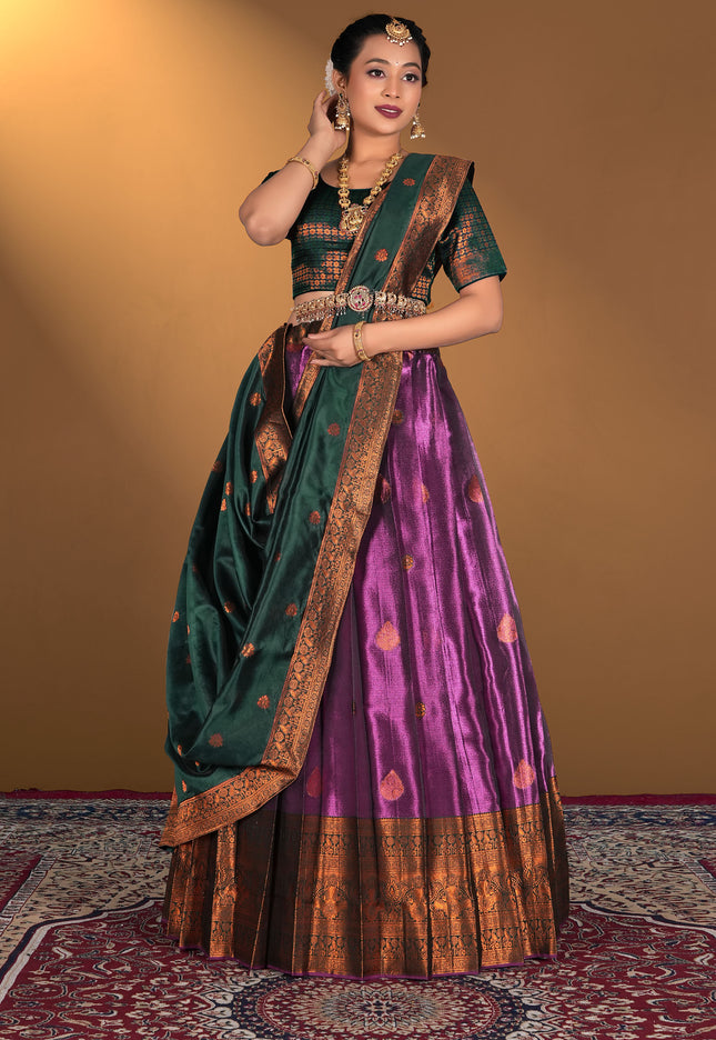 Woman wearing a traditional green and purple lehenga choli with gold border
