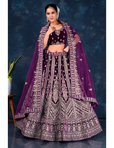 Woman wearing a traditional purple embroidered lehenga choli with dupatta