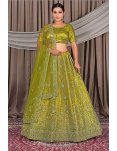 Woman wearing a green embroidered traditional outfit with a matching dupatta