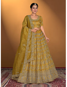 Woman wearing a traditional yellow and green outfit with intricate patterns