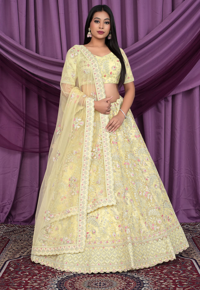Woman wearing a light yellow embroidered lehenga choli