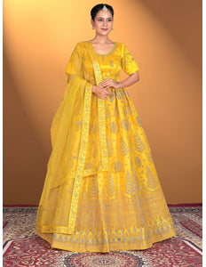 Woman wearing a yellow traditional outfit with intricate patterns