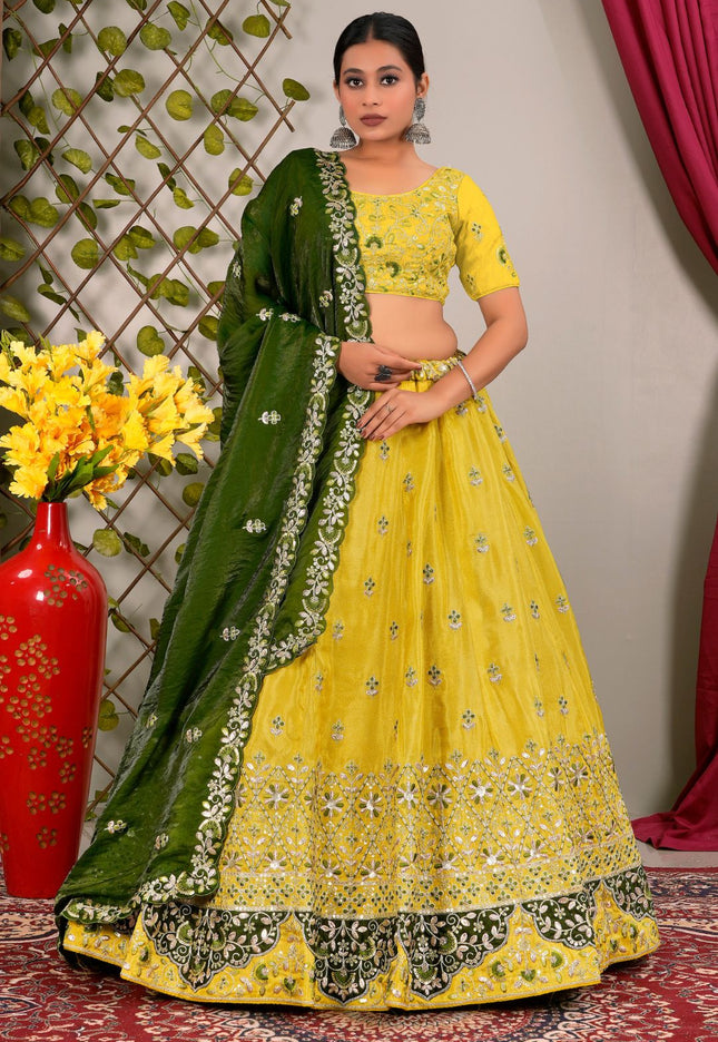 Woman wearing a yellow and green traditional outfit with floral patterns.