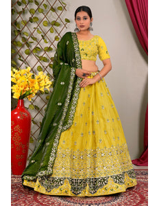 Woman wearing a yellow and green traditional outfit with floral patterns.