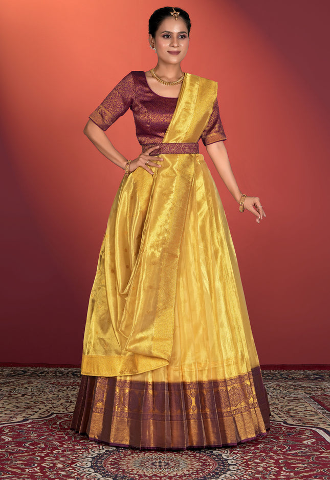Woman wearing a yellow and maroon traditional lehenga choli