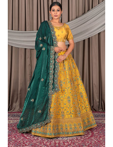 Woman wearing a yellow and green traditional outfit with a draped green dupatta