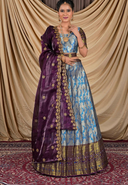 Woman wearing a traditional outfit with a purple and blue lehenga choli with dupatta