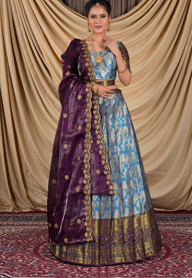 Woman wearing a traditional outfit with a purple and blue lehenga choli with dupatta